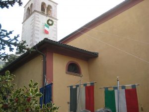 Der Kranz hängt unter der Fahne am Kirchturm